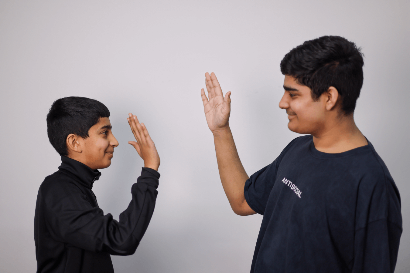 two Learning Cubs students high fiving showing their friendship