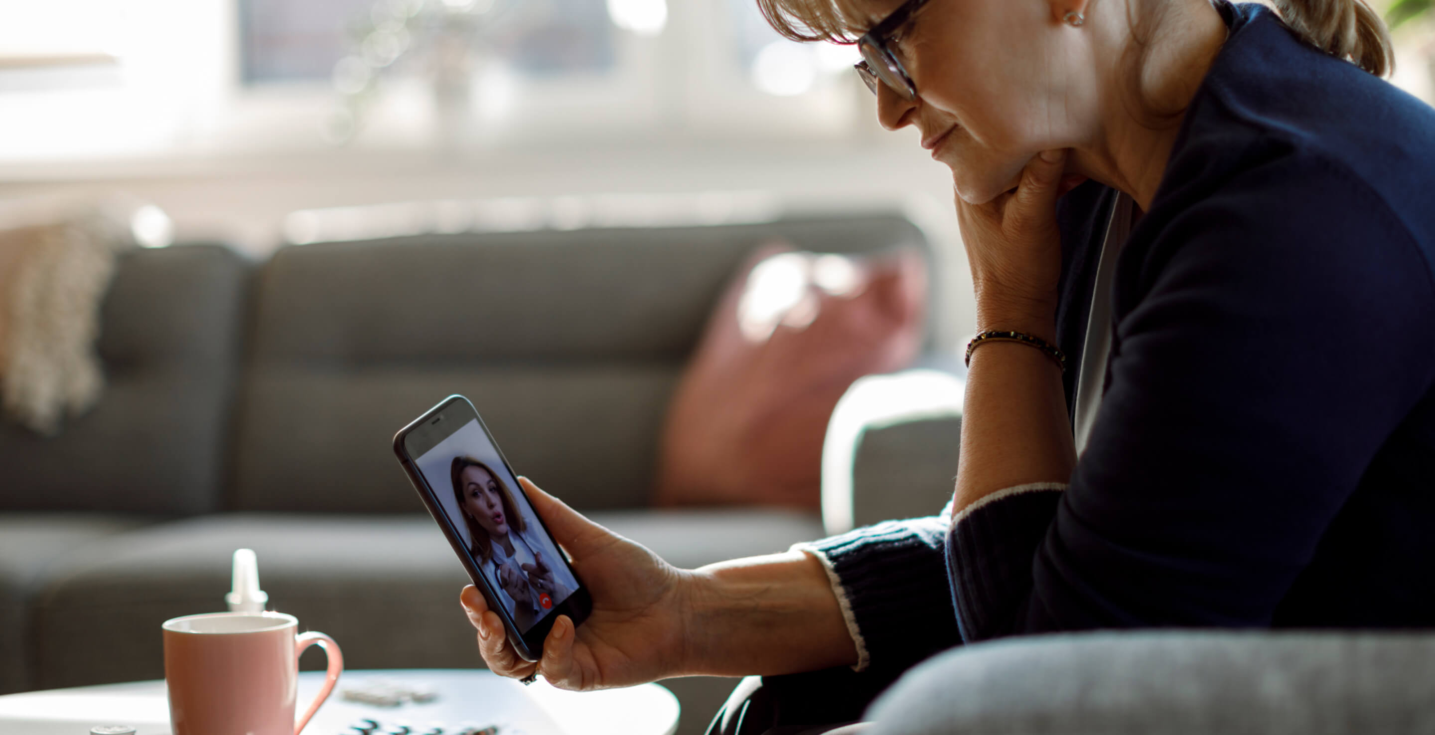 A woman in a telemedicine meeting with her provider via iphone