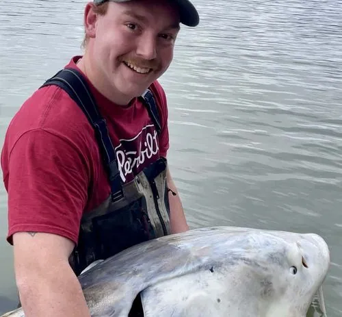 A man holding a sturgeon