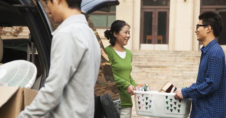 Parents helping adult son to move into student residence