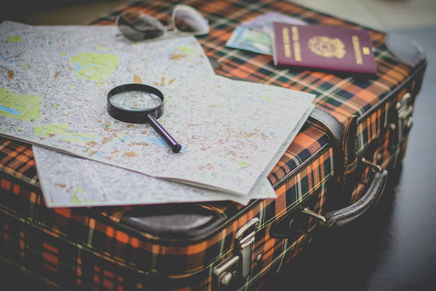 traveling plan made on a map with a passport beside it
