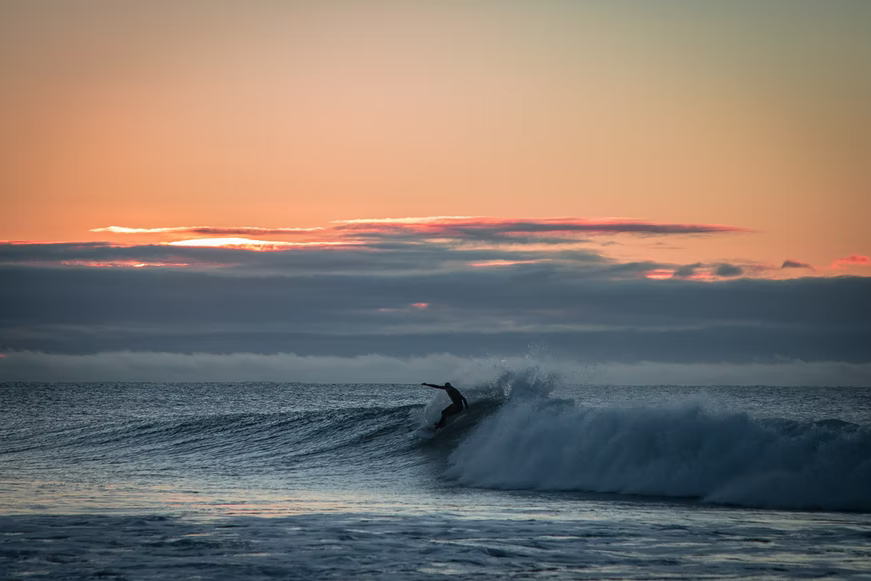 person surfing at bells beach, victoria, australia, during sunrise