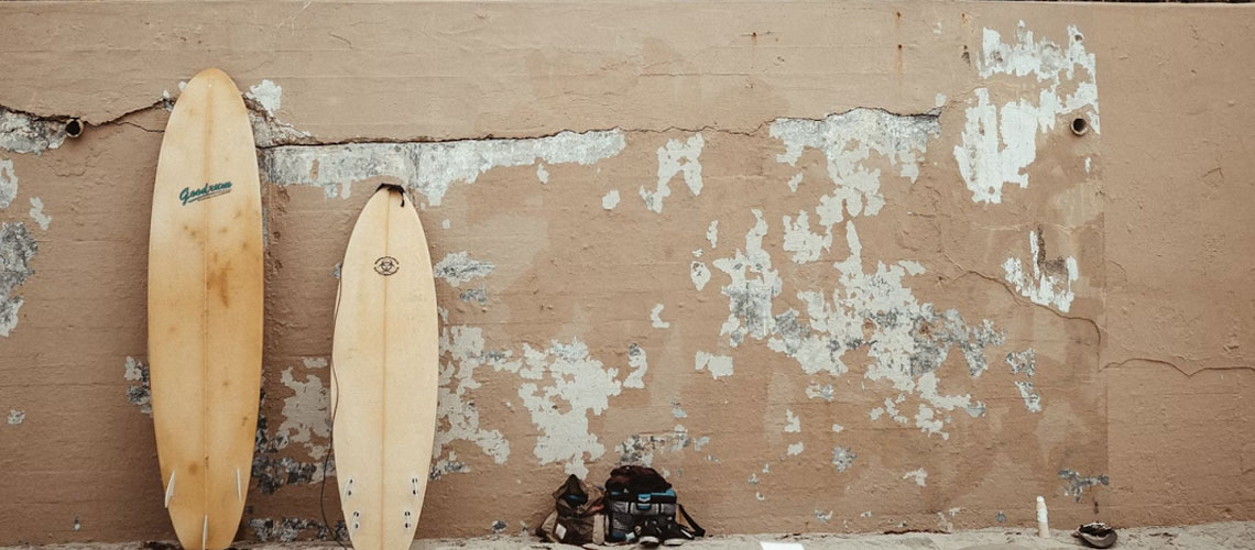 surfboards with different surfboard outline leaning on a beige wall