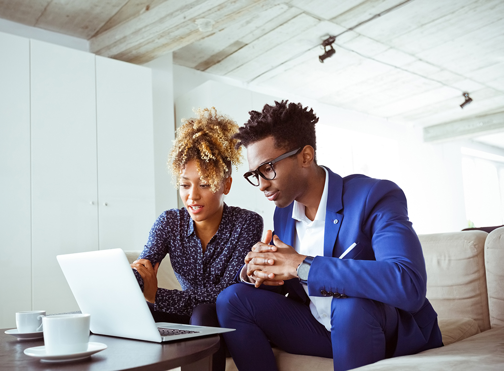 A man and a woman looking at a laptop