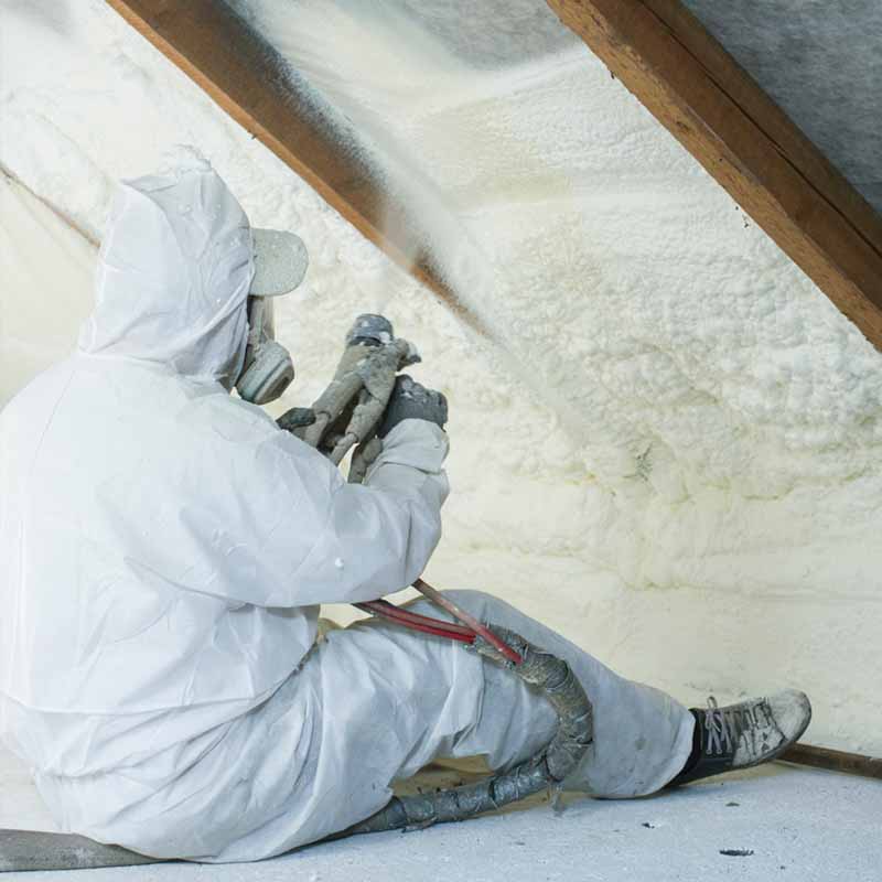 Insulation contractor applying spray foam insulation in the attic