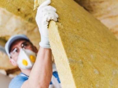 Insulation contractor placing batt insulation into the wall