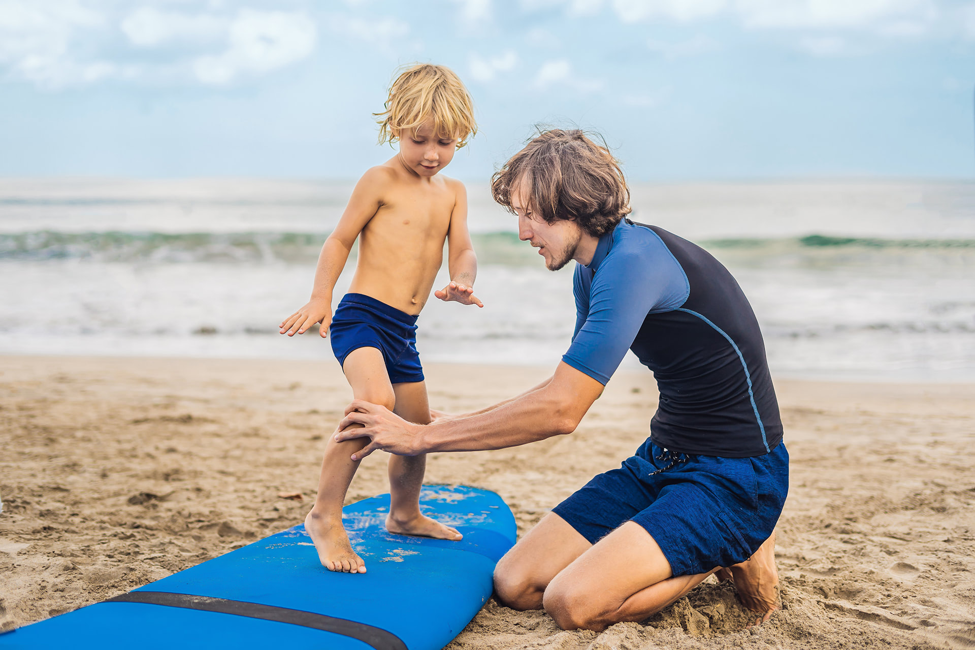 Un jeune garçon prend un cours de surf.