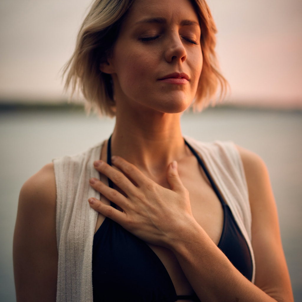A woman relaxing and taking a deep breath.
