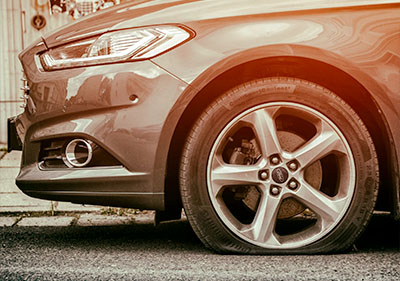 side view of the front driver wheel with a flat tire