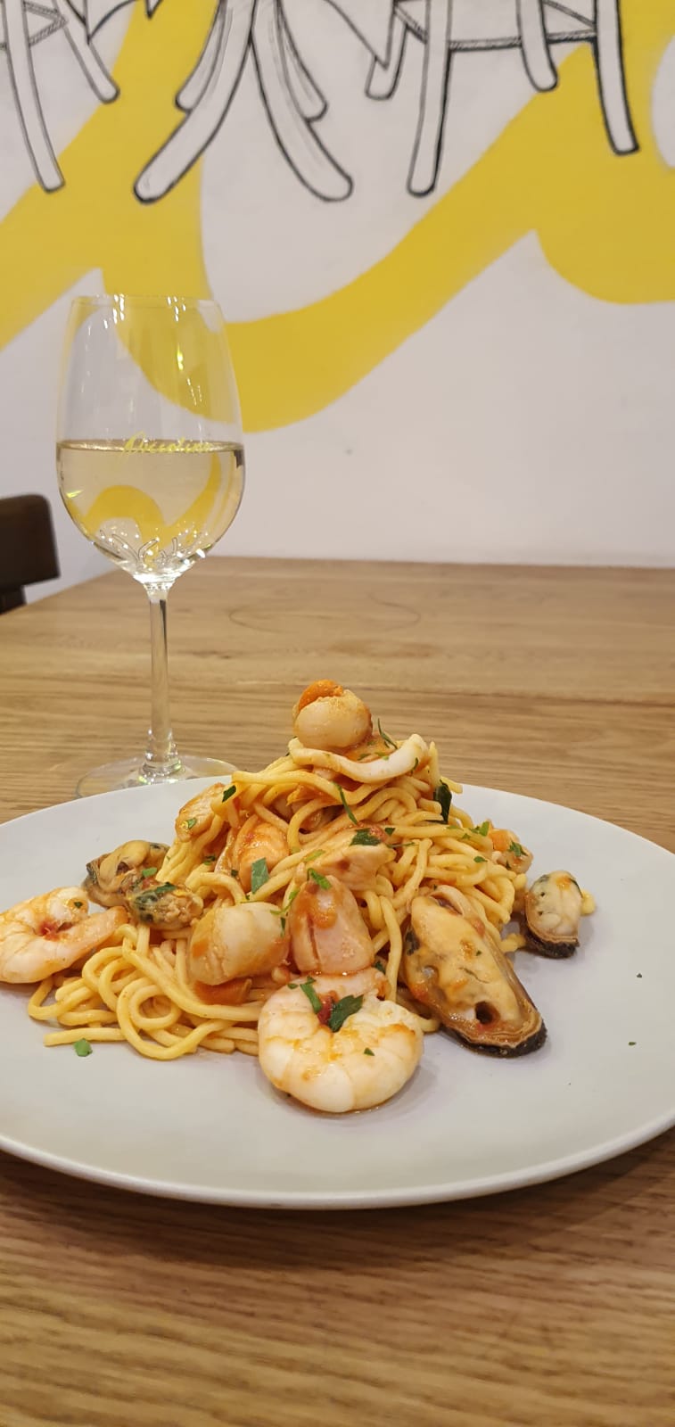 A pasta dish placed on a table top with the Piccolino logo cropped in the background.