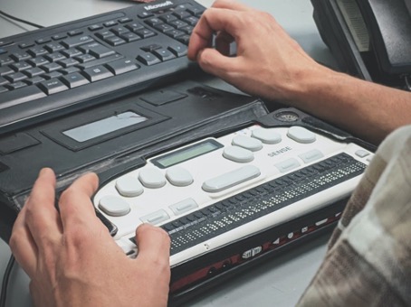 Personne malvoyante utilisant un lecteur d’écran braille