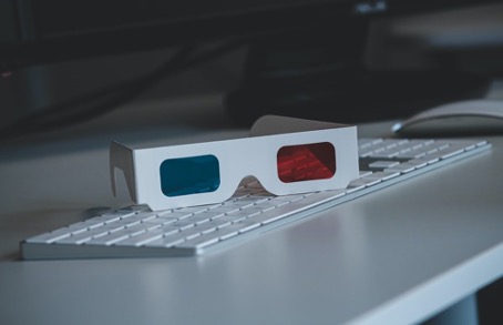 Lunette 3D rouge et bleue posées sur un clavier d’ordinateur