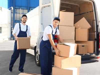 Professional movers moving boxes out of a moving van