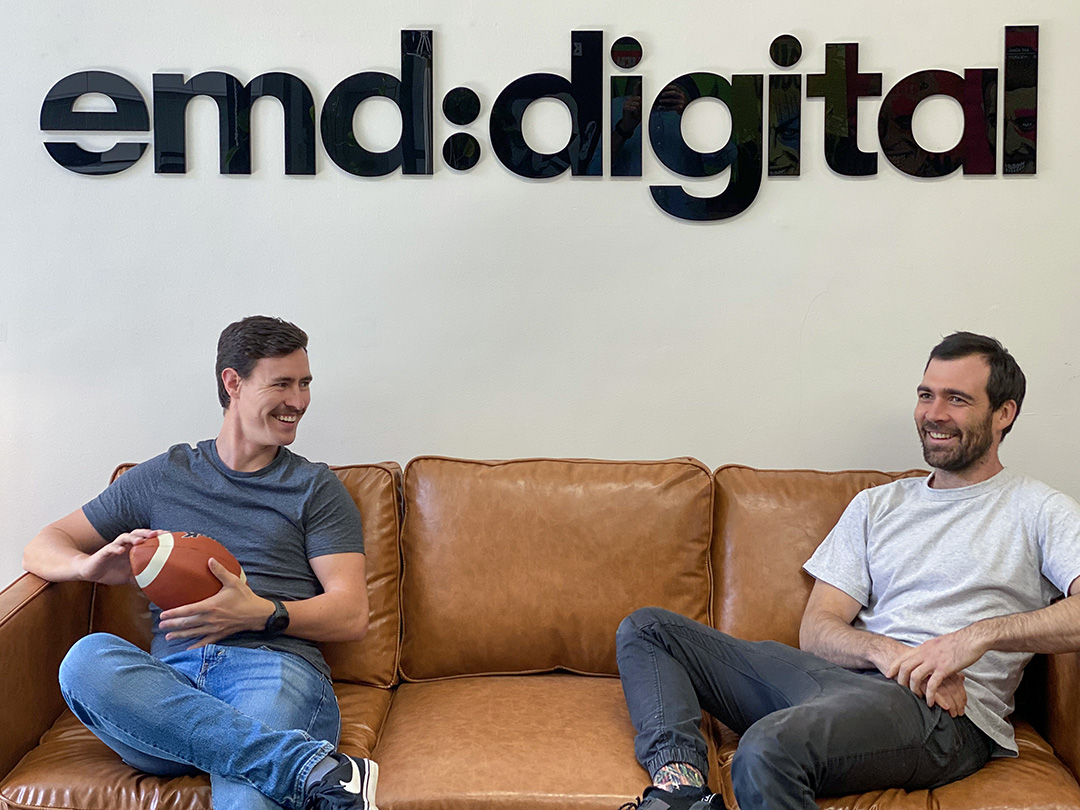 Two stunningly handsome men (Mike and Dave) chatting on the plush couch at emd:digital