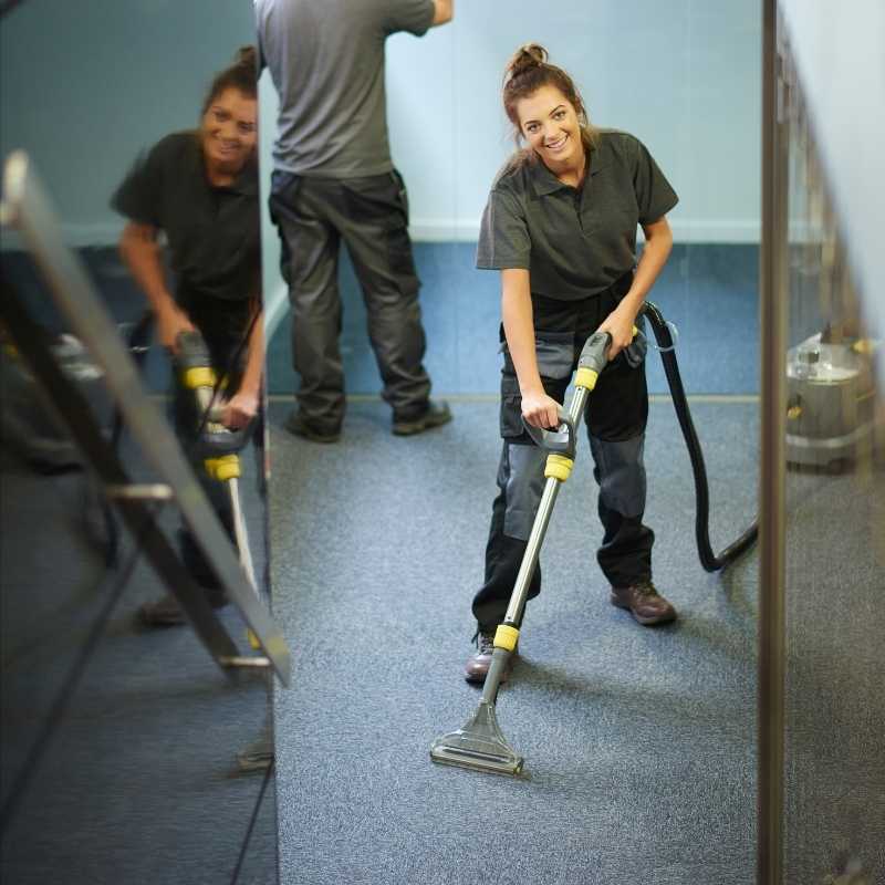 two workers cleaning carpet in a commercial office space