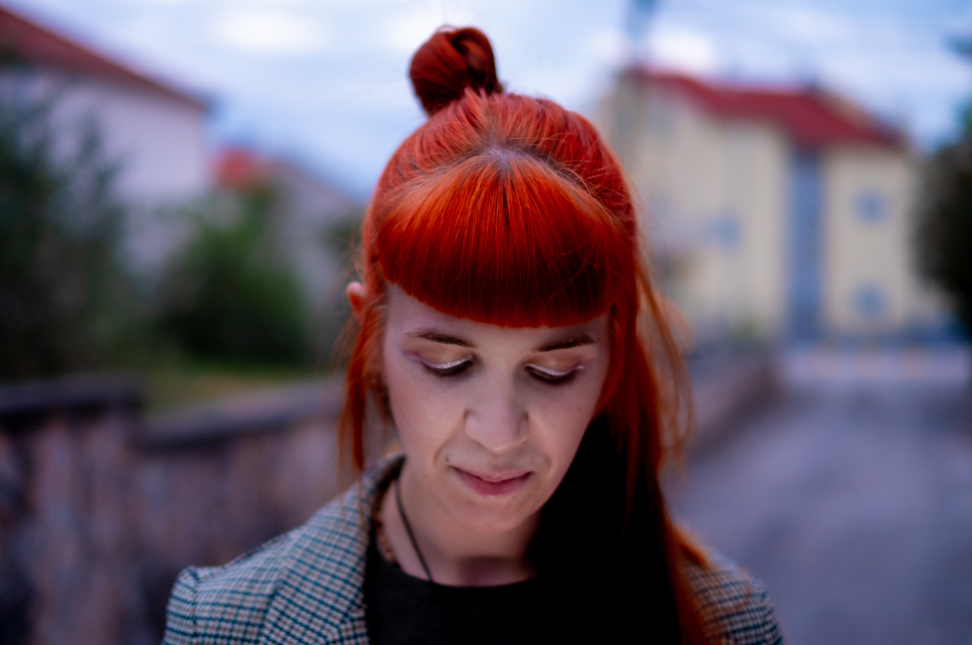 mlada crvenokosa žena oboljela i izliječena od leukemije zamišljeno šeta gradom