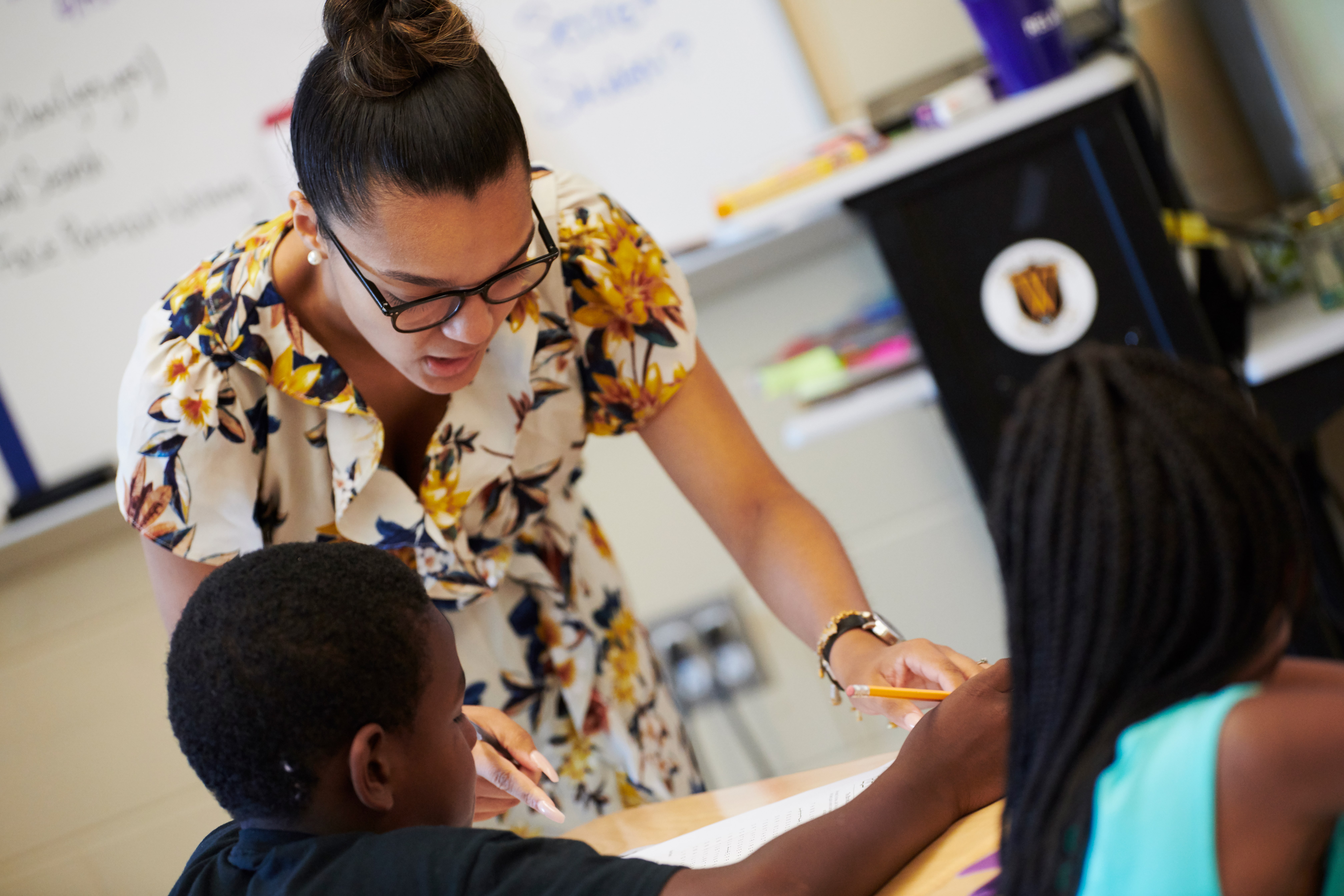 Teacher helping student with a task.