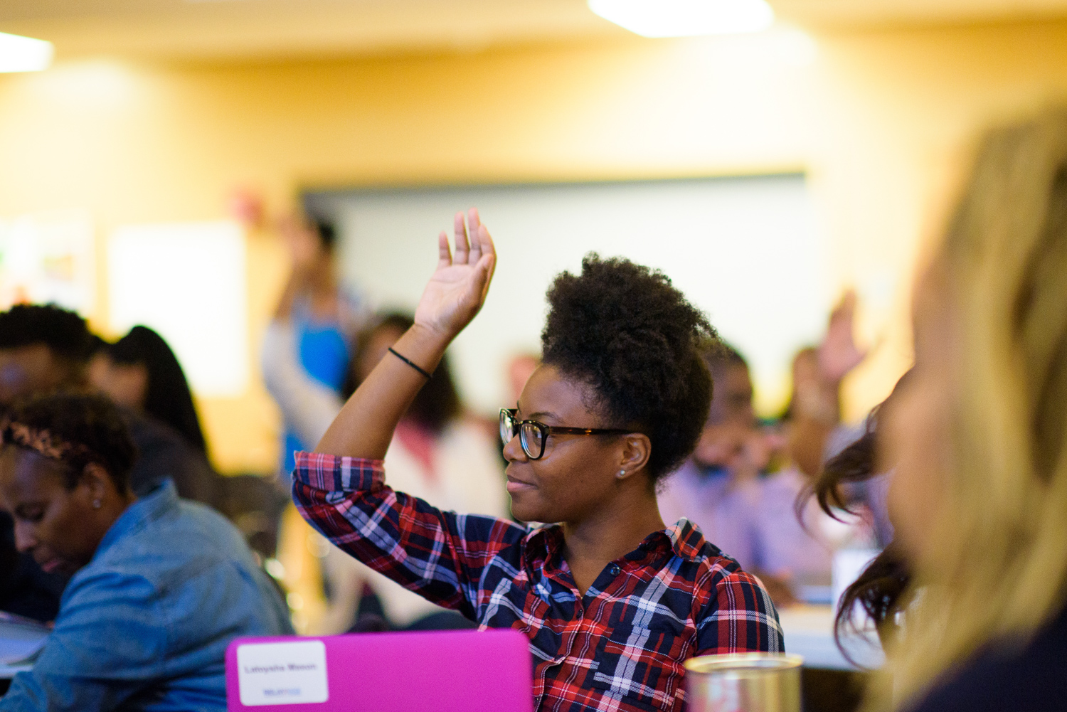 Relay student raising hand in workshop