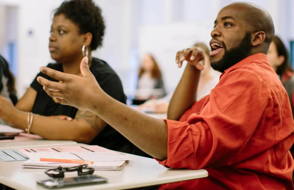Relay student in red shirt participating in discussion