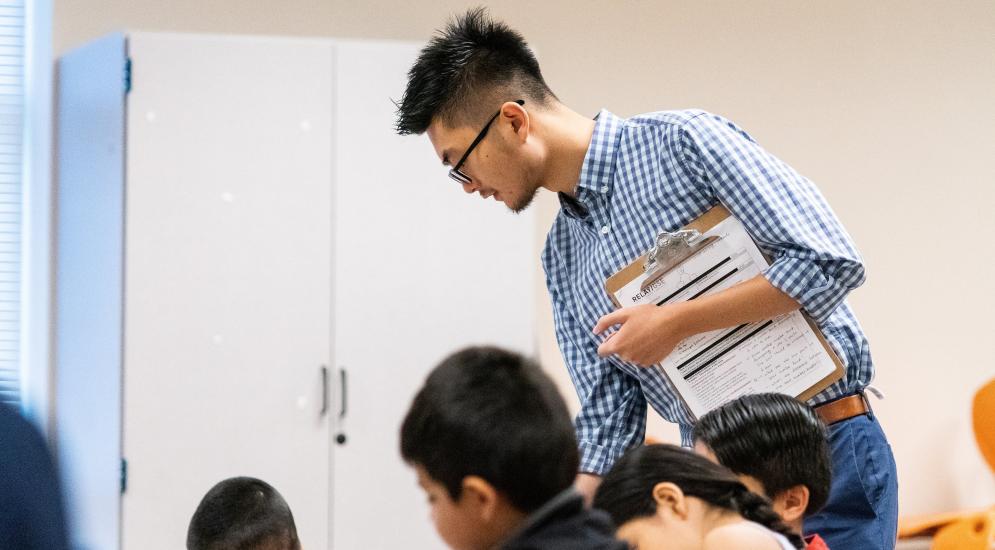 Teacher helping students with their work.