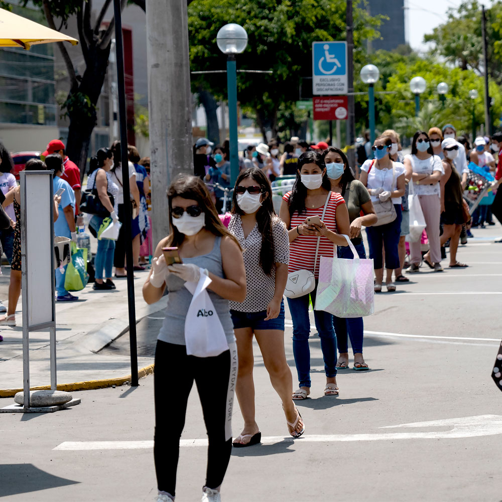Women lining up to buy groceries wearing face masks in Lima, Peru