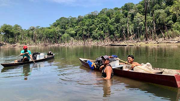 Three men working with boats on the Amazon river