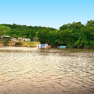 Boats and wooden buildings on the bank of the Jari River