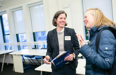 Mayme Hostetter, President of Relay Graduate School of Education, stands talking with a student