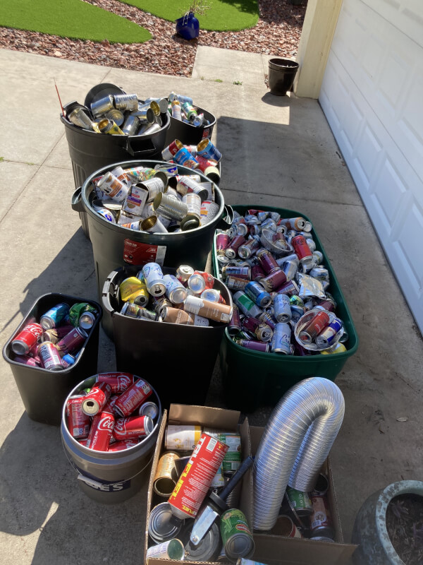 A recycling bin, and nine more garbage bins and boxes fill with empty cans