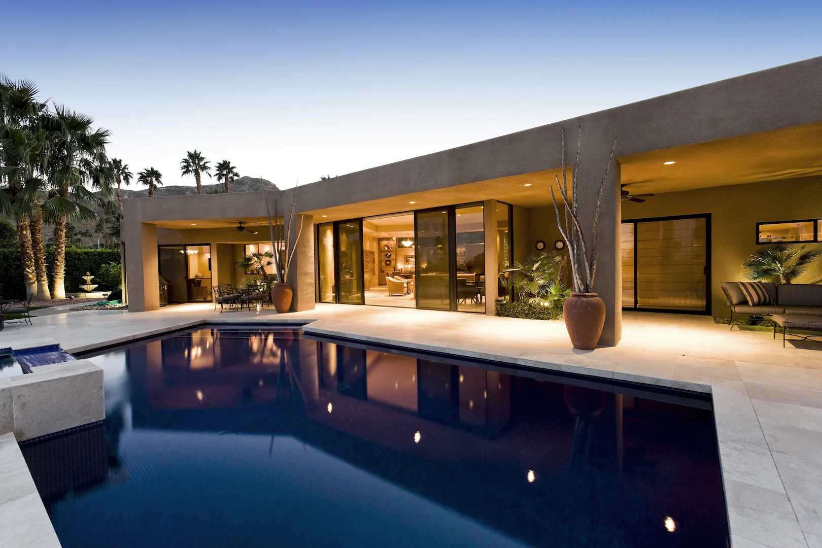 A the backyard of luxury home in Scottsdale AZ with a beautiful blue pool at sunset.