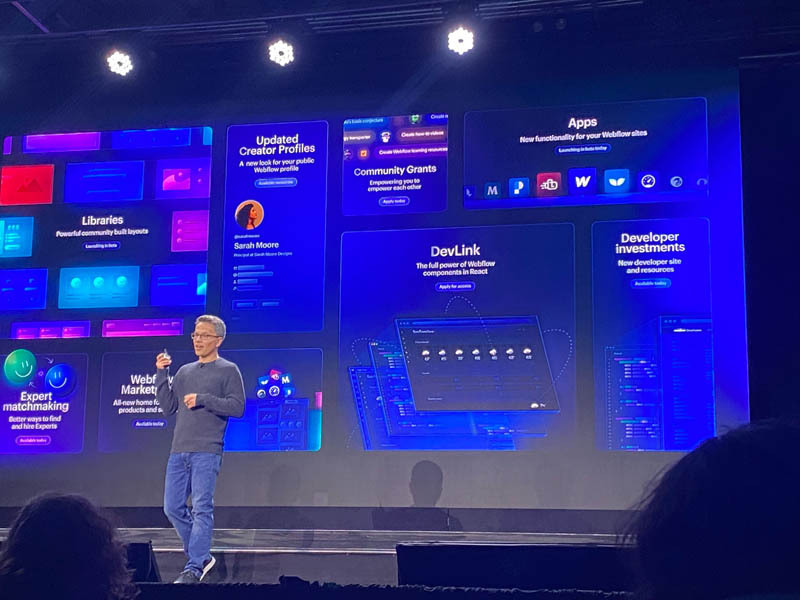 Vlad standing on a stage with a image in the background showing all the new webflow features