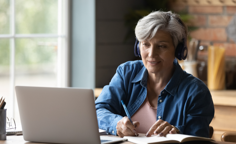 Middle aged woman sat on a video call at her laptop on a training session