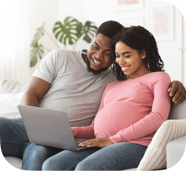 A black couple looking at a laptop together