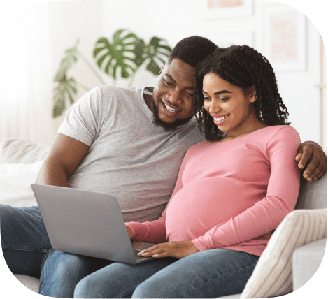 A black couple looking at a laptop together