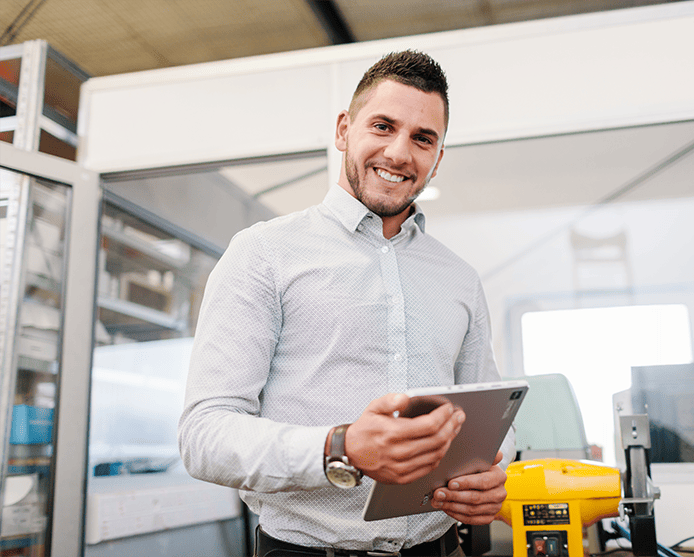 Man smiling and holding an iPad.