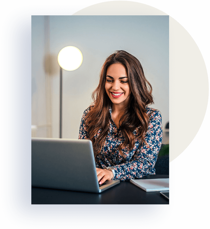 Woman using a laptop smiling.