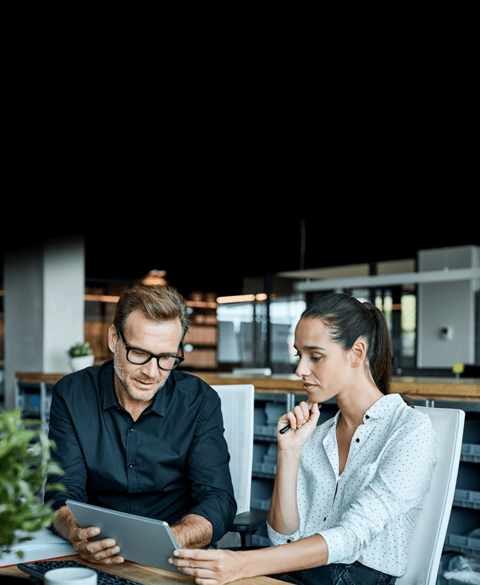 Two people gathered around a tablet.