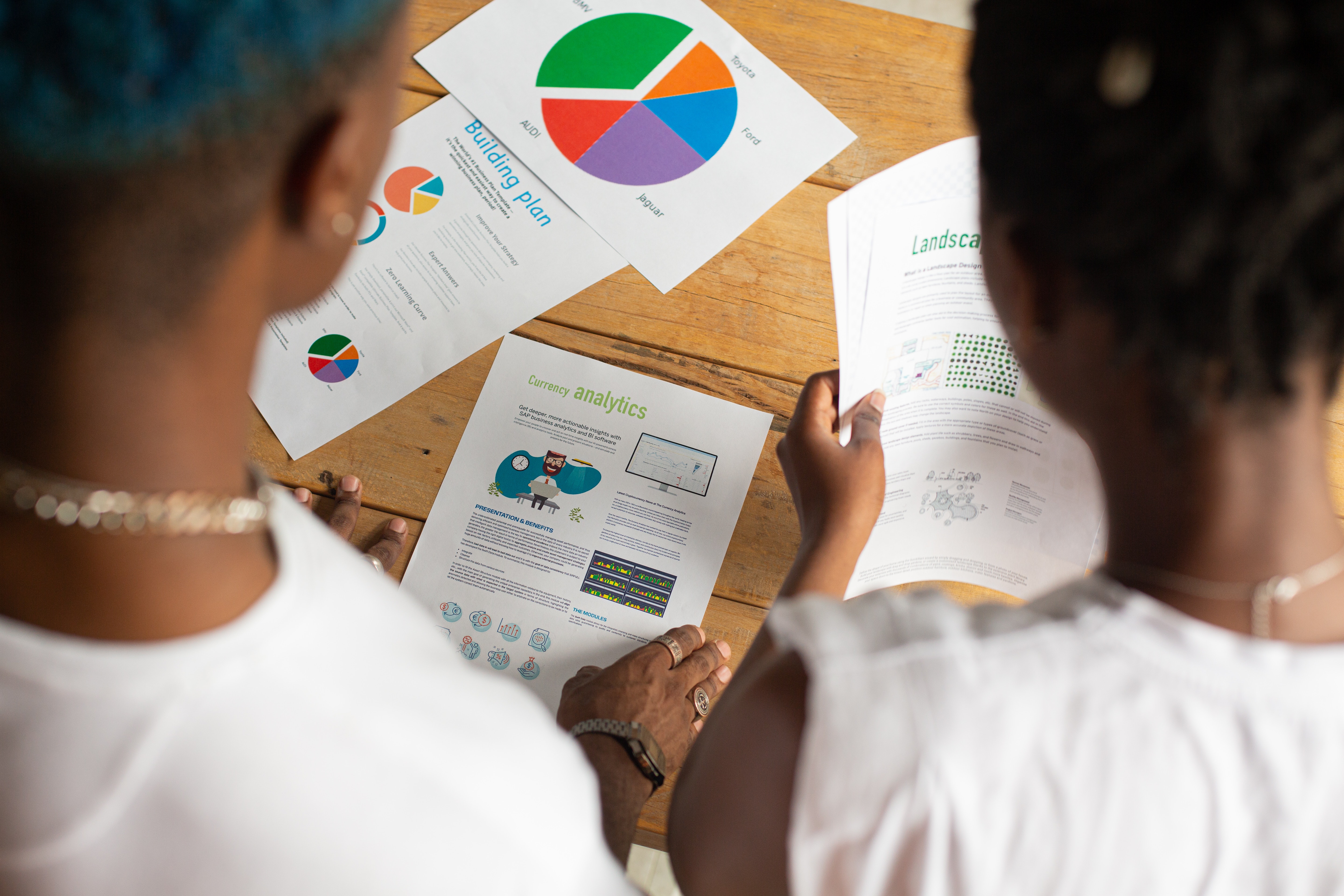 Crop unrecognizable black coworkers analyzing diagrams