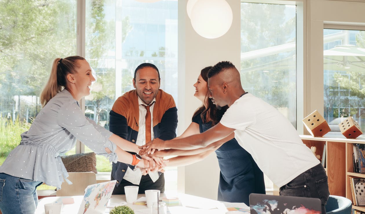 People joining hands in a meeting