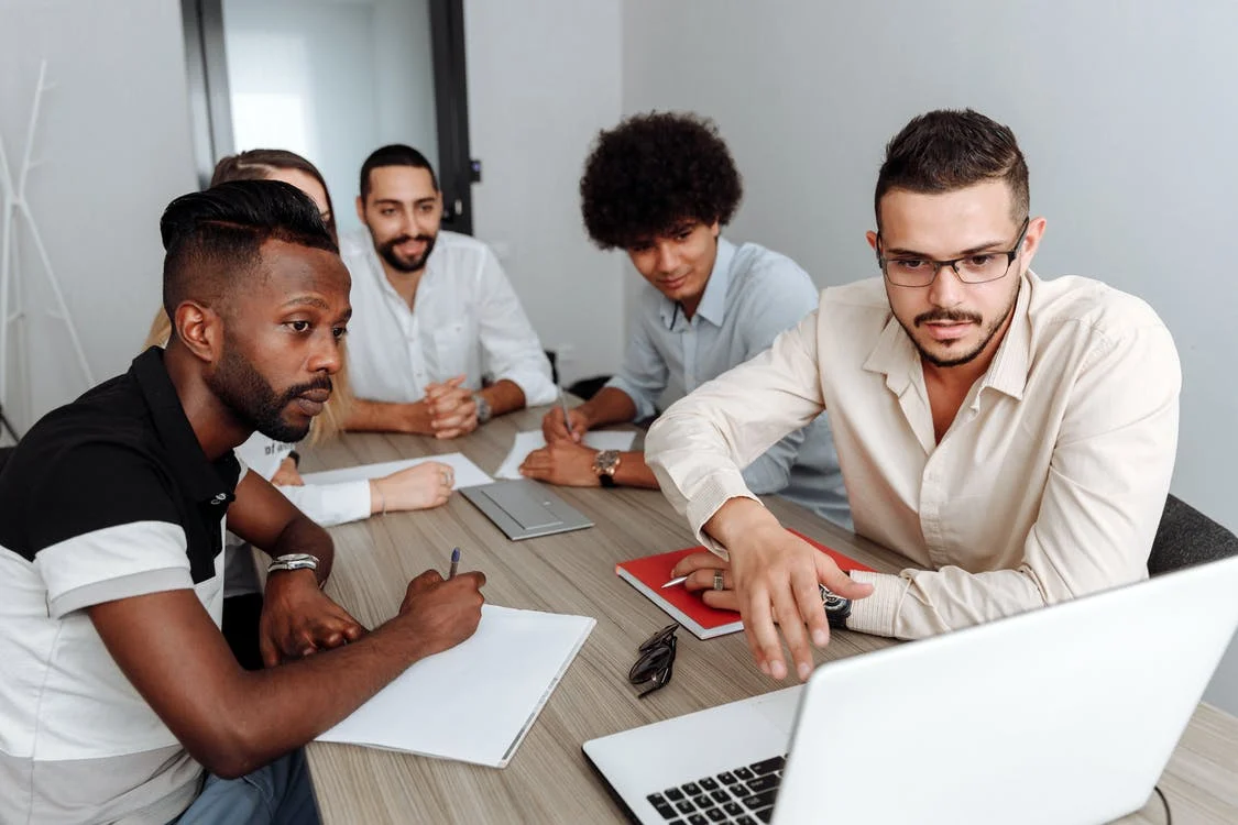 People in a meeting looking at a laptop