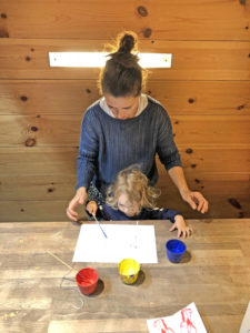 Blog Author Corrie sitting at a table with her child, doing arts and crafts.