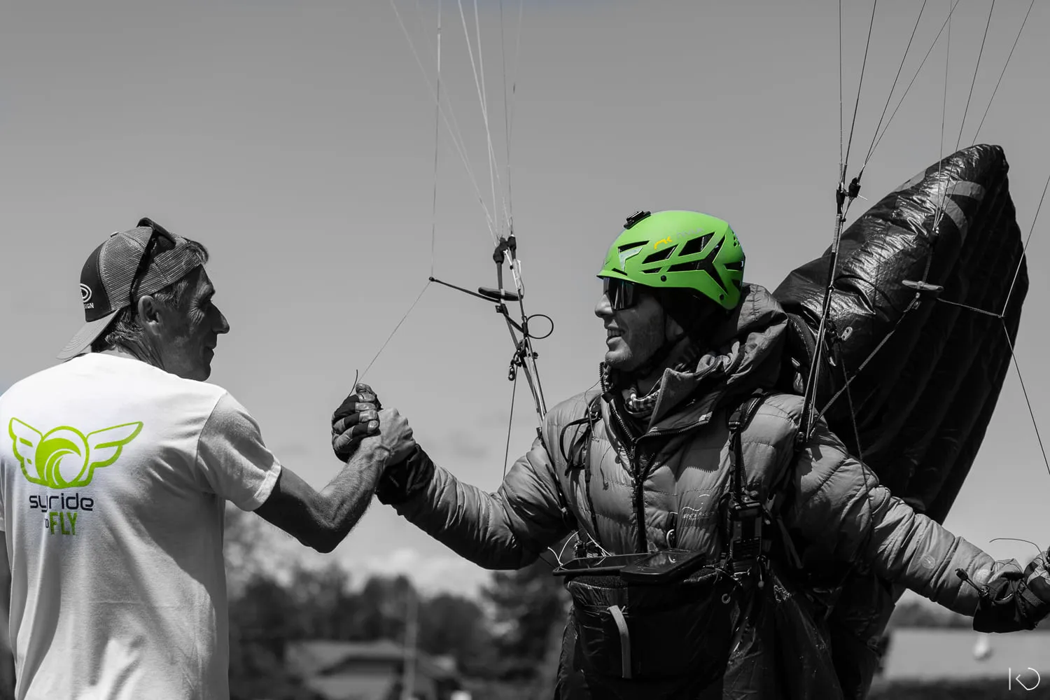 Deux hommes se serrant la main à l'arrivée de la Bornes To Fly, course de parapent marche et vol à Annecy