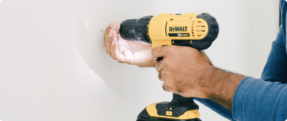 Driller making a whole in the wall