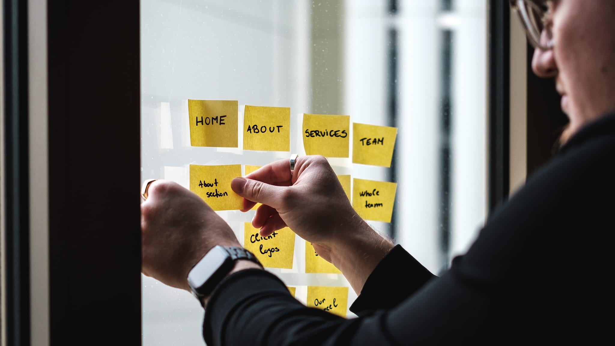 Web designer sticking website notes to window