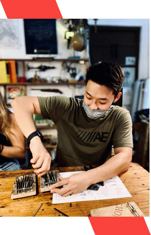 A young adult man wearing a mask while working in a workshop