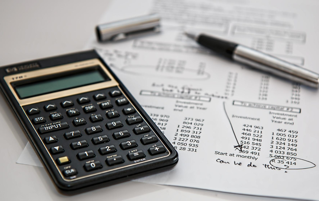 A calculator, pen, and medical bill on a table. On the bill is handwritten "can we do this?"