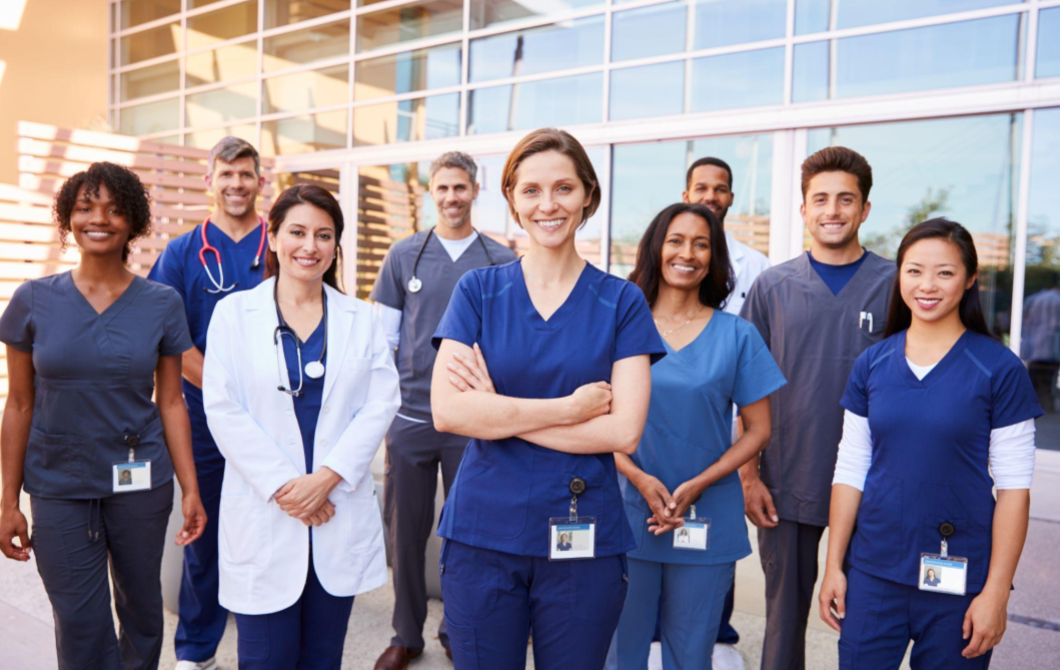 A team of medical professionals, including psychiatrists, stands outside a medical facility