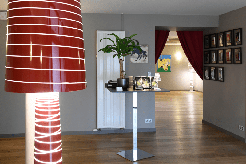 Salle avec une lampe, des fleurs et des cadres