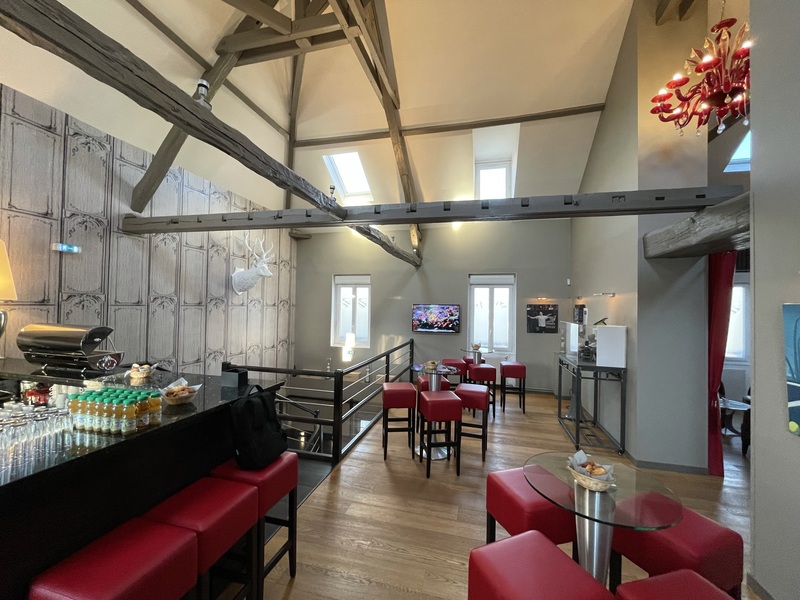 L'étage avec le bar de l'Open space et des tabourets hauts, rouge, en cuirs