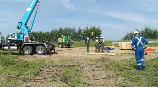 Man walking in field and a large crane at work